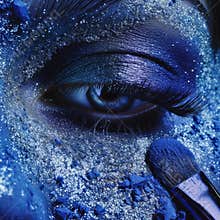 Eye makeup. Beautiful shiny eye makeup. Macro and creative close up makeup theme: beautiful female eyes with blue skin