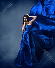 Woman in blue dress with flying silk fabric