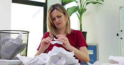 Frustrated at work and a woman struggles with documents and finds required document in the trash