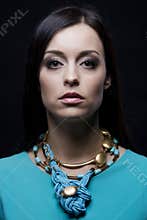 Fashion model wearing cyan clothes and jewellery