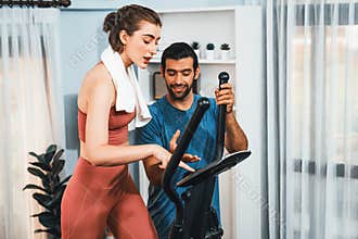 Athletic and sporty couple running on elliptical running machine at gaiety home.