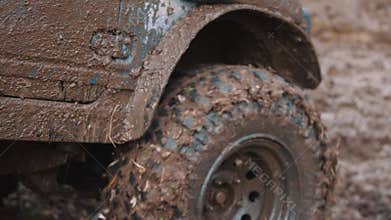 Getting off the beaten path. Car wheels on steppe terrain splashing with dirt. SUV or offroader on mud road