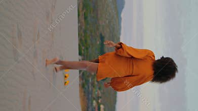 Woman jogging sand desert at twilight. Unknown girl crouching on sand vertical