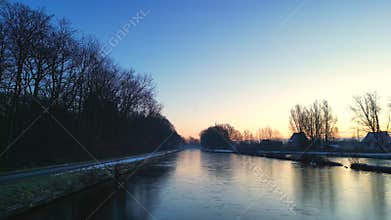 Crisp Winter Morning: Sunrise Over a Frosty Canal