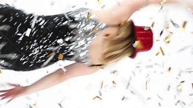 Happy blonde woman jumping dancing throws sparkling confetti.