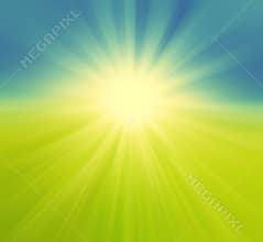 Blurry green field and blue sky with summer sun bu