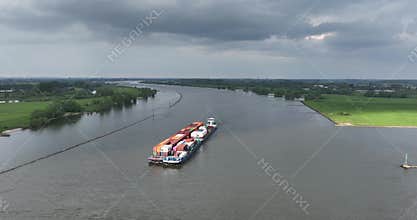 Aerial view on the Waal river, container shipping, transportation over water in The Netherlands.