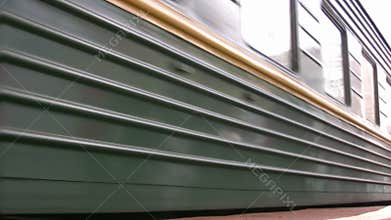 Wagon of green train near passenger