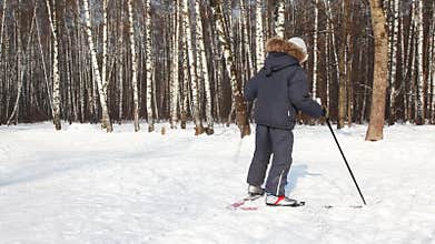Young boy turns on skis around its axis by day in