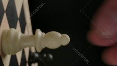 Vertical of Man's hand moving white bishop chess piece from first line
