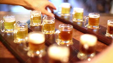 Barman puts paddles with noggins full of beer on