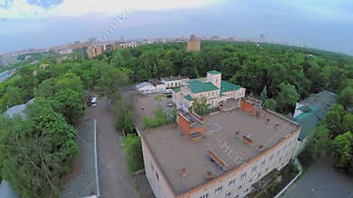 Builds among plants of large park with cityscape