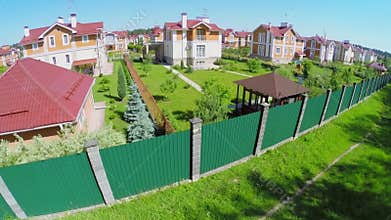 Gated development with green fence at sunny summer