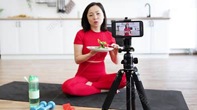 Woman recording fitness and healthy eating video at home
