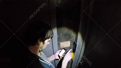 Man opens code lock in dark room of quest room