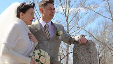 bridegroom and bride with bouquet stands