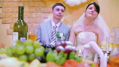 bridegroom and bride sits at wedding table and