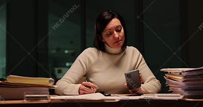 Responsible woman checks reports at work late at night