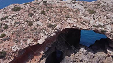 Natural windows in the rocks, Comino Island Malta, Close up drone shot
