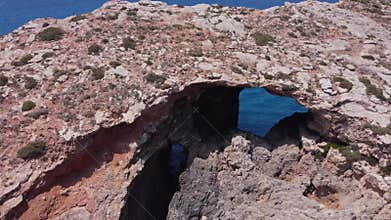 Natural windows in the rocks, Comino Island Malta, Close up drone shot
