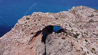 Natural windows in the rocks, Comino Island Malta, Close up drone shot