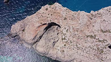Natural windows in the rocks, Comino Island Malta, Close up revealing drone shot