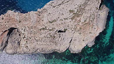 Natural windows in the rocks, Comino Island Malta, Close up revealing drone shot