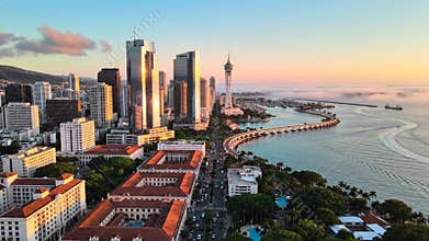 City skyline along the coastline at sunset with modern high-rises and waterfront promenade
