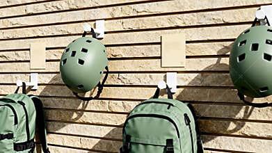 Display of green sports helmets and backpacks in a modern environment with a natural stone backdrop