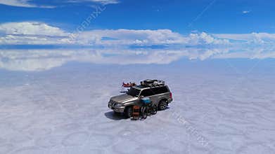 A serene picnic on the expansive Salar de Uyuni salt flats in Bolivia, under a clear blue sky
