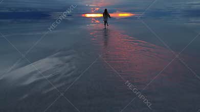 A breathtaking sunset over a salt lake in Bolivia, capturing the solitary figure of a runner against the vibrant sky