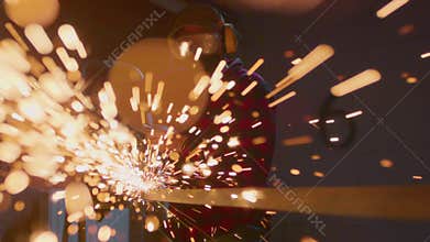 Man working at factory cuts metal with a grinder. Male at a construction site cuts off piece. Guy Industrial worker use angle