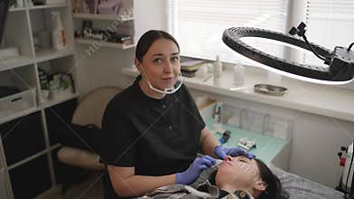 Professional cosmetologist performing a lip blushing permanent makeup procedure