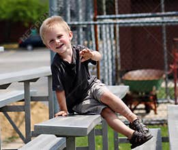 Adorable Toddler Boy sitting on the bleachers at a baseball game