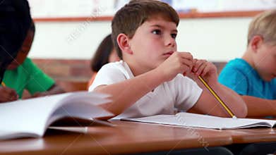 Little boy writing during class