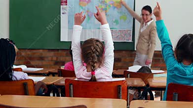 Little children listening to teacher showing the map in classroom