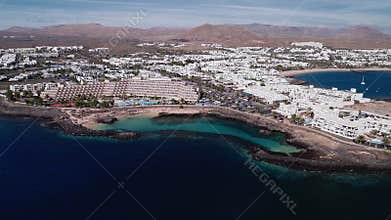 Aerial sweep of Lanzarote resorts and lava coast with coves