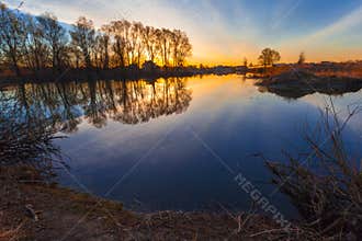 Rural summer sunrise landscape with river and dramatic colorful sky