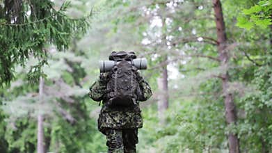 Young soldier with backpack in forest