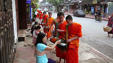 LUANG PRABANG, LAOS - APRIL 2014: people give rice to monks