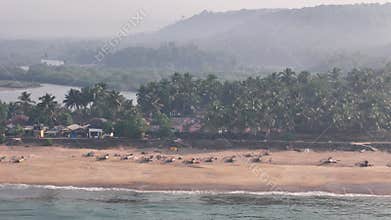 Sweeping aerial view of Kelus Kalvi, a traditional fishing village on a sandy beach at a river mouth on the beautiful Konkan coast