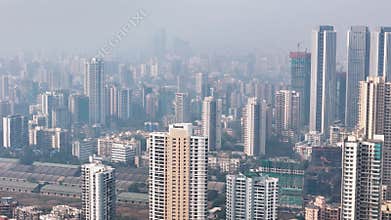 Aerial shot of Mumbai\'s dense urban sprawl, featuring countless high-rise apartment buildings and construction