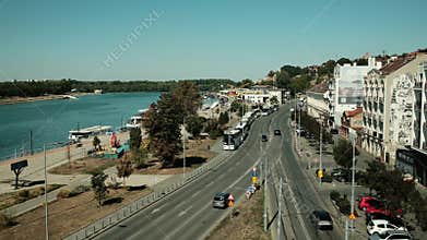 Cityscape of Belgrade with street view, cars, buses, and buildings near the riverside promenade on a sunny day. Horizontal 4k