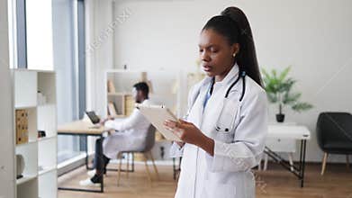 Healthcare professional reviewing patient data on a tablet in modern office