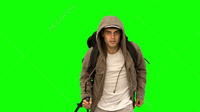 Man with a coat and a hiking stick running on green screen