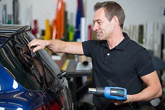 Car wrapper tinting vehicle window with foil