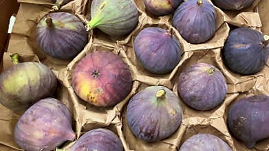 Black figs arranged in cardboard crate