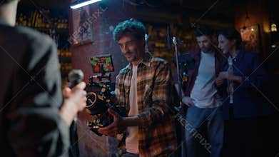 Enthusiastic videographer recording rock performance in night club stage closeup