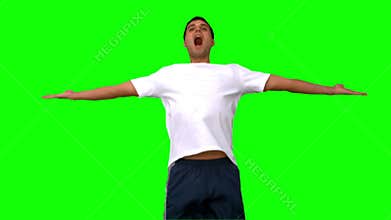 Handsome man jumping and raising arms on green screen