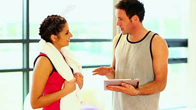 Handsome coach talking to sporty woman